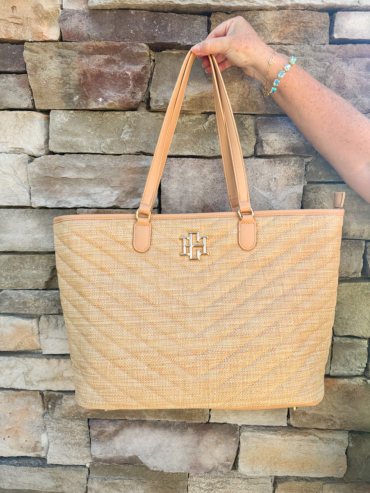 Natural oversized V-quilted straw tote with vegan leather trim, zipper closure, and multiple interior pockets