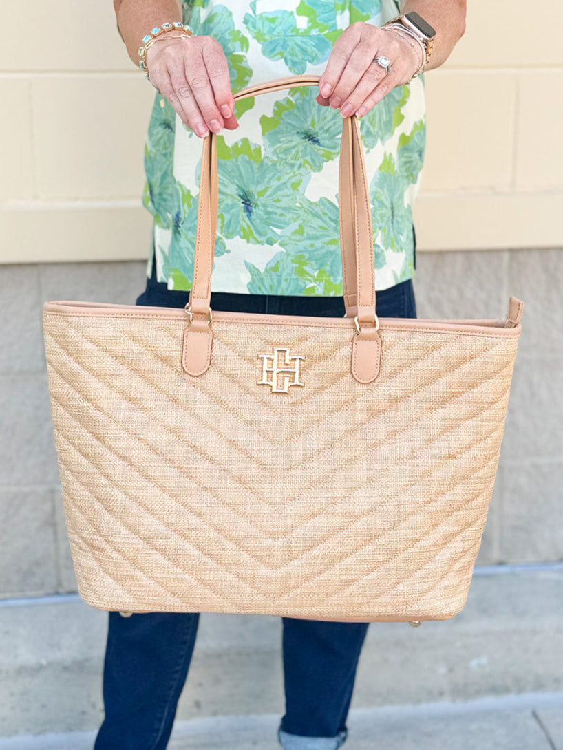 Natural oversized V-quilted straw tote with vegan leather trim, zipper closure, and multiple interior pockets
