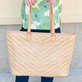 Natural oversized V-quilted straw tote with vegan leather trim, zipper closure, and multiple interior pockets