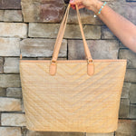 Natural oversized V-quilted straw tote with vegan leather trim, zipper closure, and multiple interior pockets