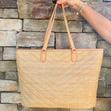 Natural oversized V-quilted straw tote with vegan leather trim, zipper closure, and multiple interior pockets