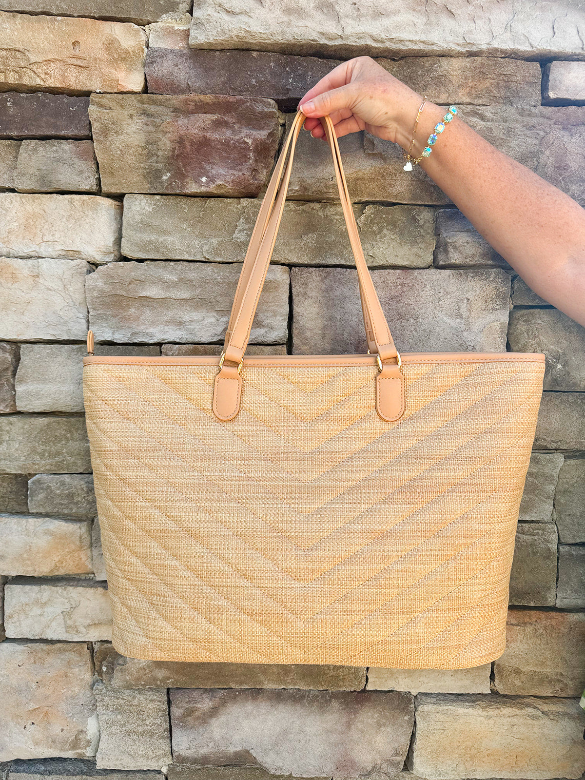 Natural oversized V-quilted straw tote with vegan leather trim, zipper closure, and multiple interior pockets