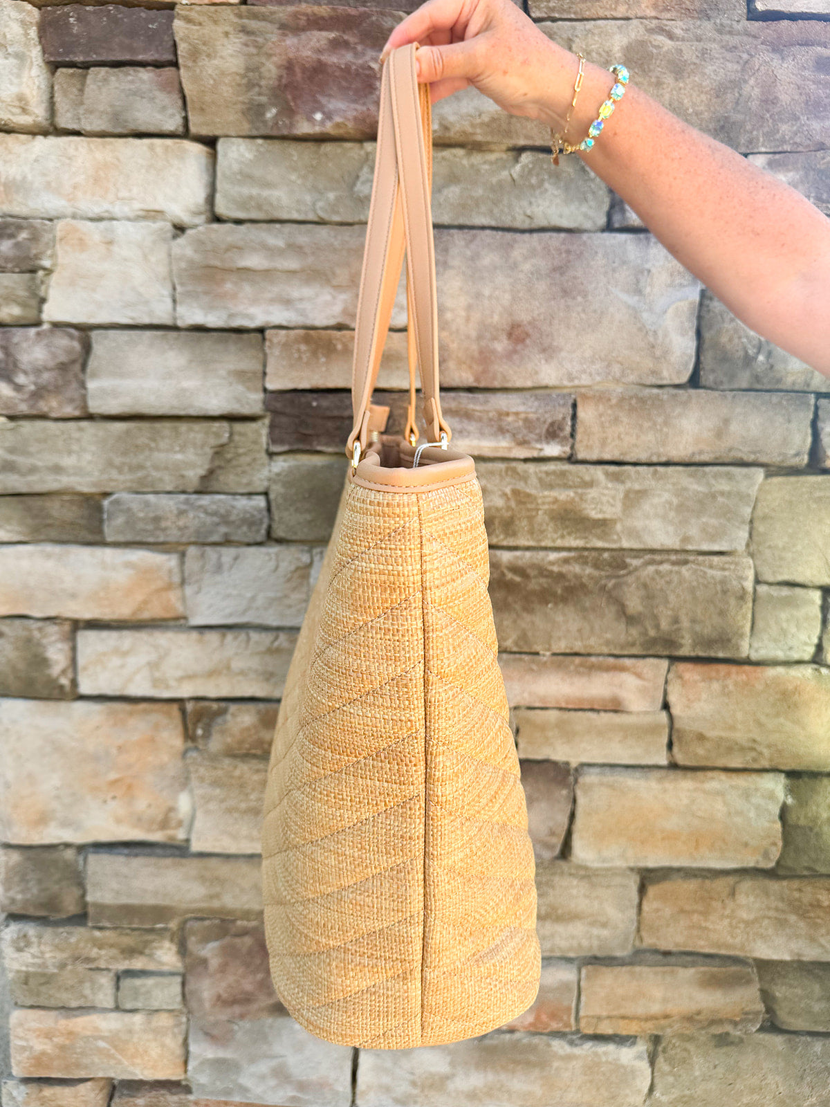 Natural oversized V-quilted straw tote with vegan leather trim, zipper closure, and multiple interior pockets