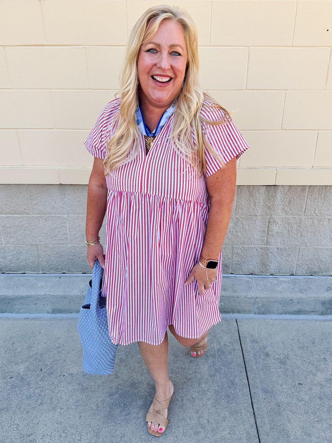 Red and white striped babydoll mini dress with V-neckline and short drop sleeves, styled for playful summer days.
