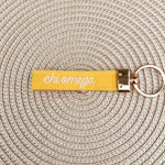 Double-sided embroidered Chi Omega sorority keychain featuring Greek letters, script sorority name, and polished gold hardware.