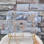 Clearly Handbags Ginger clear PVC bag with gold-plated chain, hardware, and lock detail.