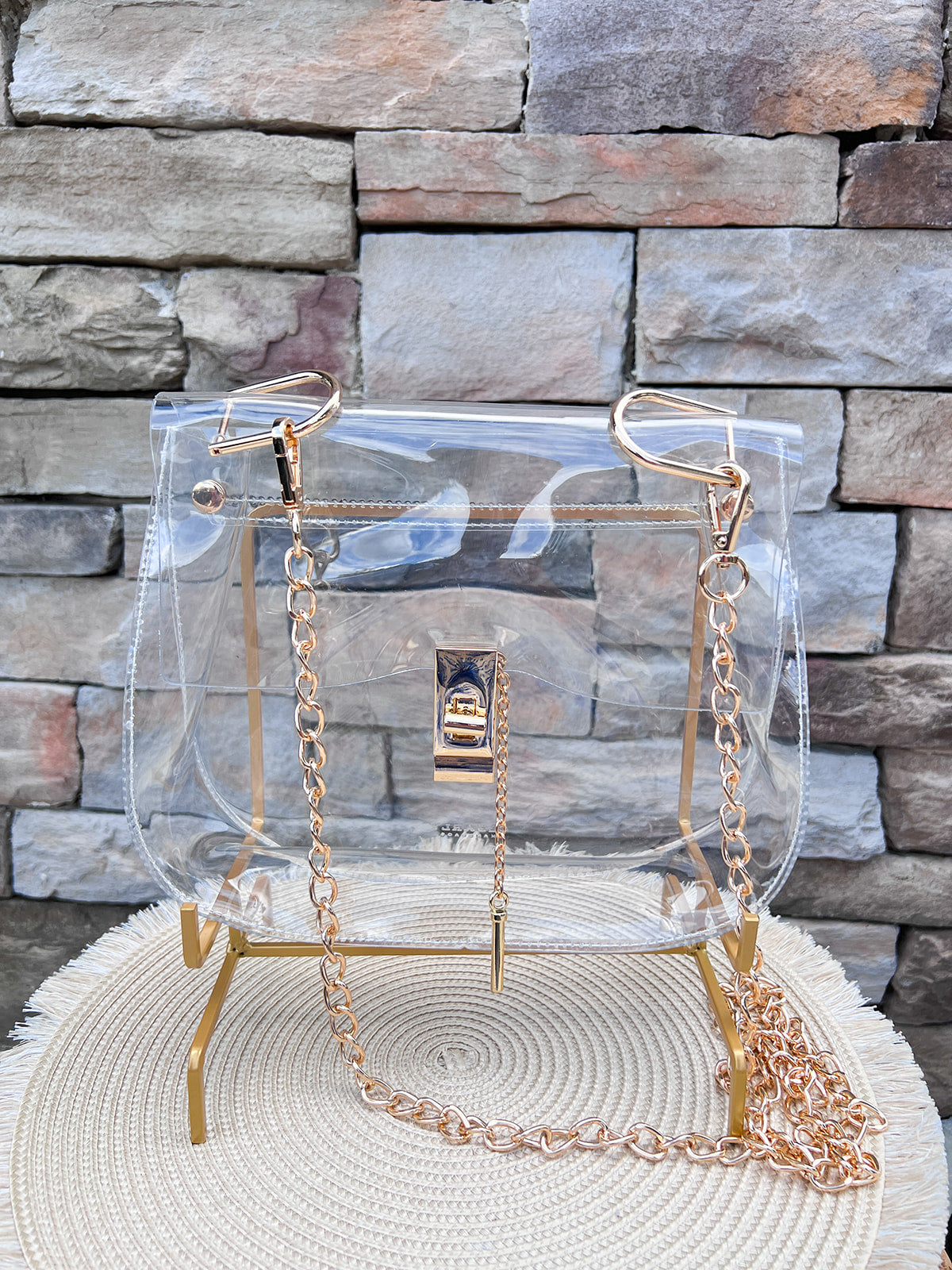 Clearly Handbags Ginger clear PVC bag with gold-plated chain, hardware, and lock detail.