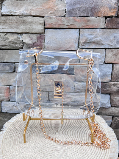 Clearly Handbags Ginger clear PVC bag with gold-plated chain, hardware, and lock detail.
