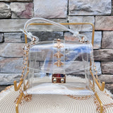 Clearly Handbags Kathryn clear PVC handbag with gold bee stud accents, removable gold chain strap, and structured silhouette.