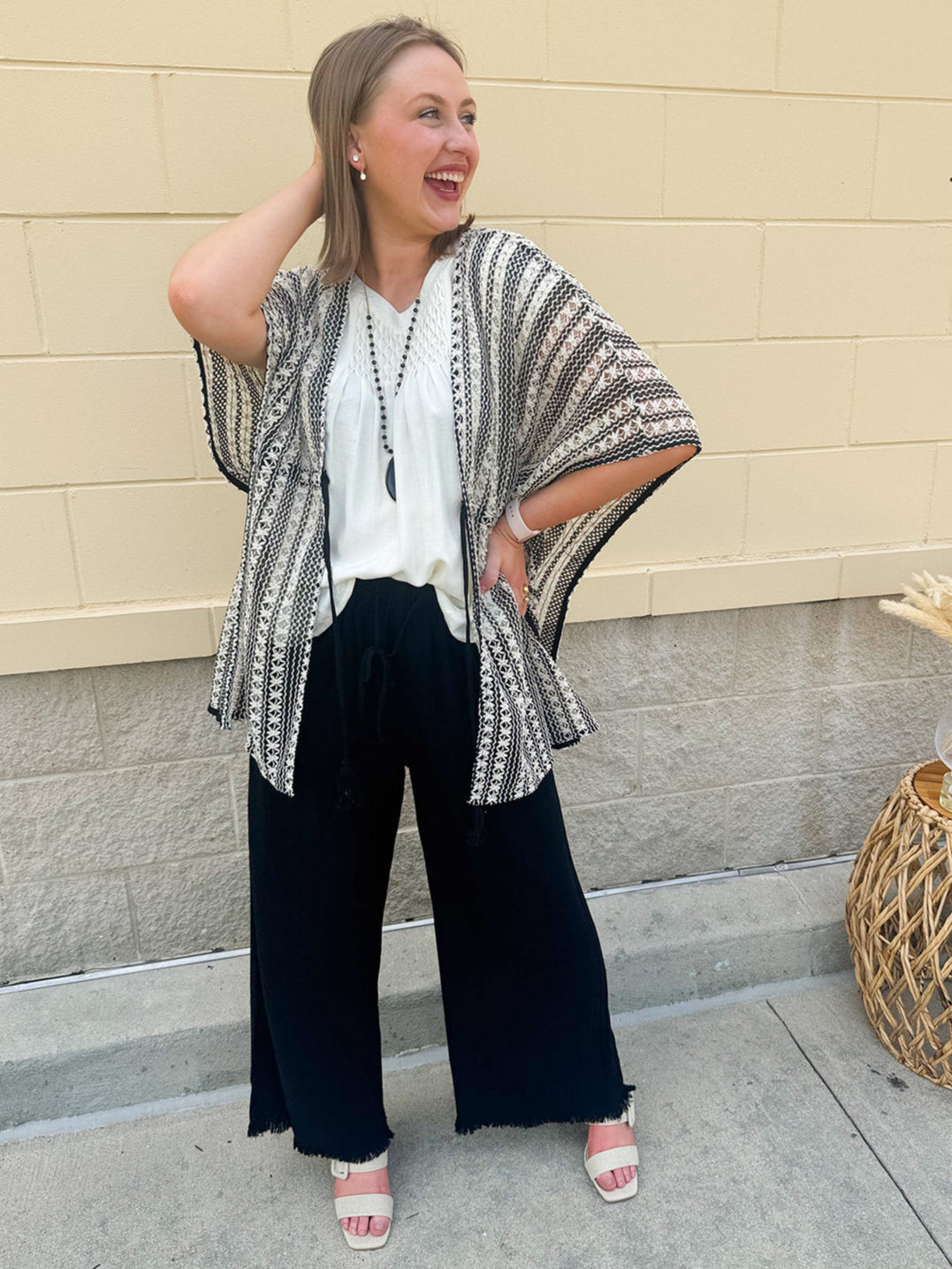 Striped tunic-length kimono cardigan with front tie, half sleeves, and boho-inspired poncho silhouette.