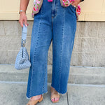 Medium wash wide leg jeans with mid rise, front seam, and front slits for a flattering, modern fit.