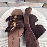 Chocolate brown faux suede wedge sandals with double straps and oversized gold buckles.