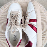 White Corkys lace-up sneakers with burgundy accent stripes and a classic low-top silhouette.