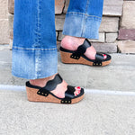 Black scalloped wedge sandals with cork sole, gold hardware accents, and dual straps—stylish and comfortable for everyday wear.