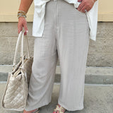 Wide-leg linen pants in a stone color with high-rise waist and pockets, styled for casual elegance.