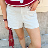 Stone high rise woven shorts with front patch pockets, clean hem, and structured silhouette.