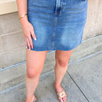 Medium wash denim mini skirt with a high-rise waist, classic five-pocket styling, and a flattering fitted silhouette.