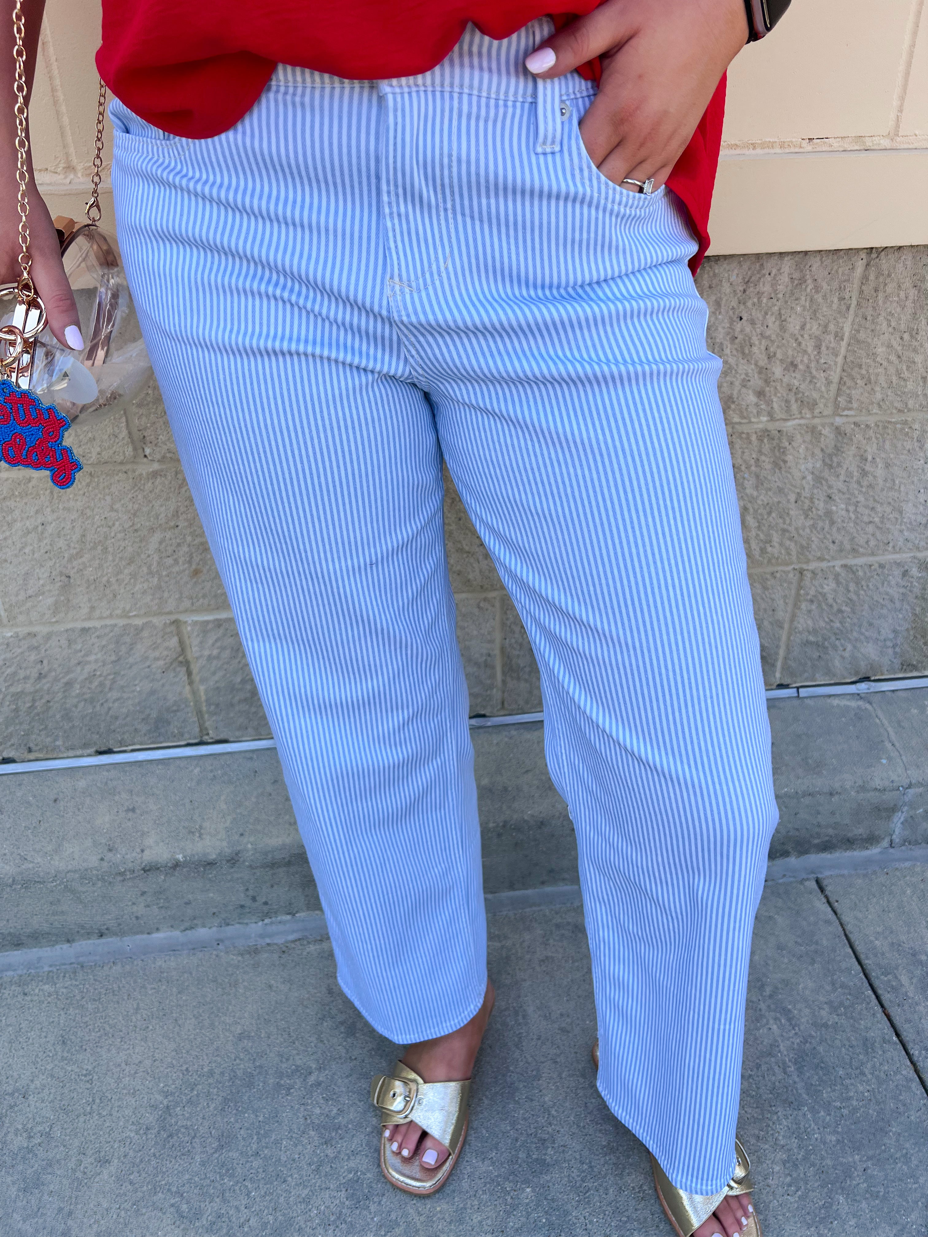 Mid-rise straight leg jeans featuring a white denim base with subtle blue vertical stripes and a clean hem.
