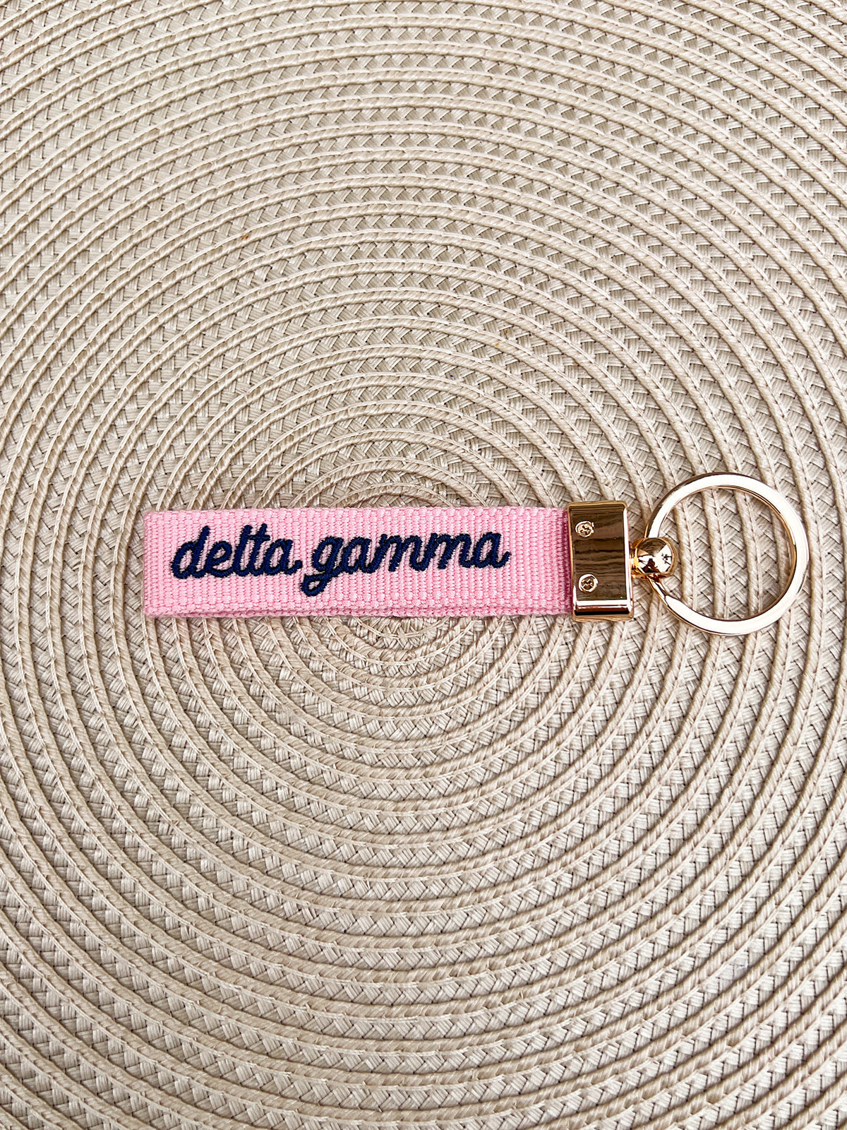 Double-sided embroidered Delta Gamma sorority keychain featuring Greek letters, script sorority name, and polished gold hardware.