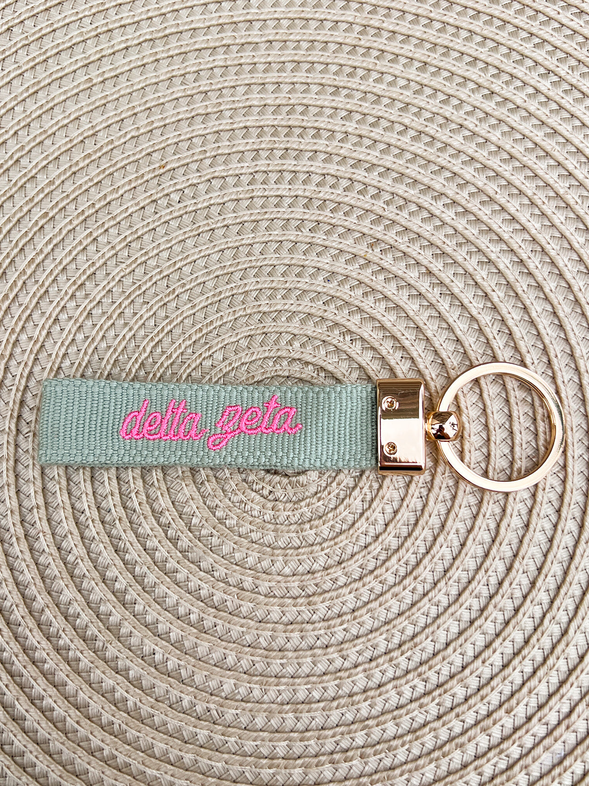 Double-sided embroidered Delta Zeta sorority keychain featuring Greek letters, script sorority name, and polished gold hardware.
