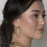 Long, slender gold hoop earrings with crystal shimmer and secure clip back closure