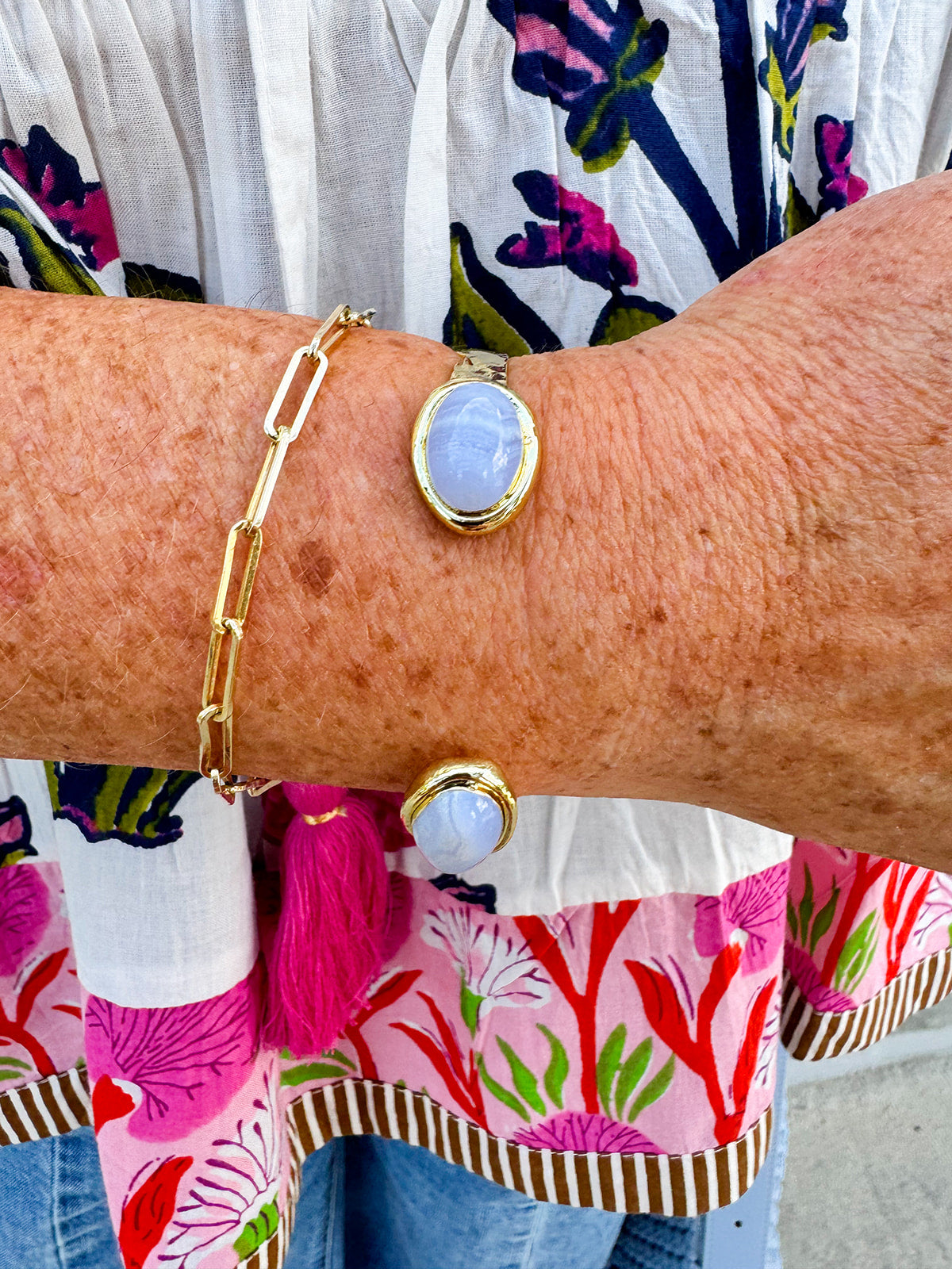 Gold cuff bracelet with an oval blue lace agate stone at the center, offering soft blue tones and a serene, elegant feel.