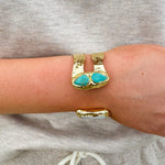 Gold double cuff bracelet featuring a mother of pearl on one end and a turquoise stone on the other—elegant, stylish, and stackable.