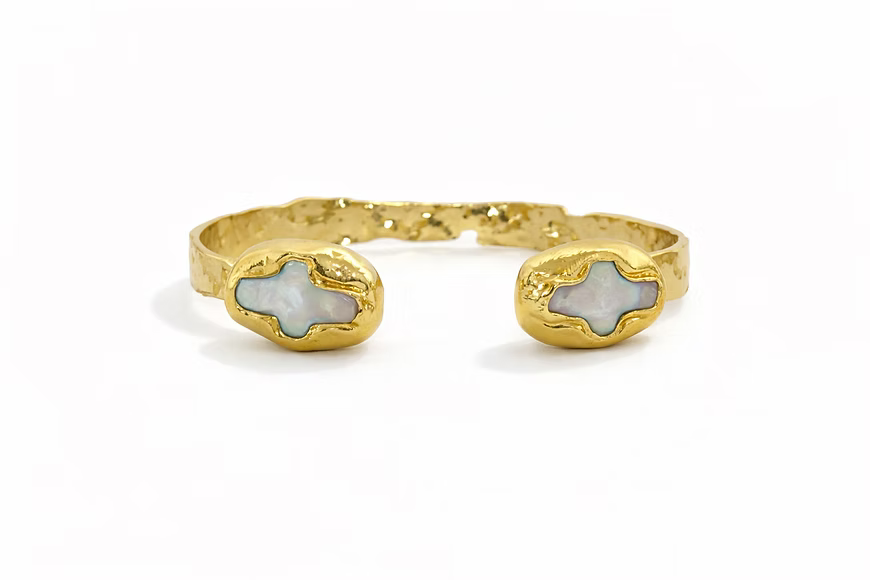 Adjustable 18K gold-plated cuff bracelet featuring luminous pearl and cross-inspired accents
