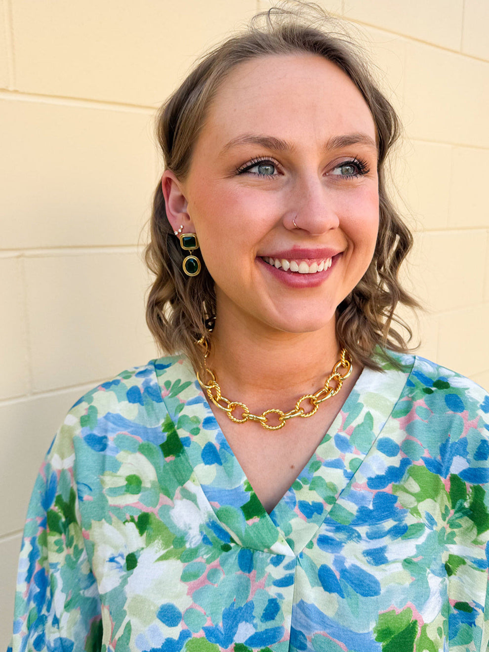 Dangle earrings with emerald green rectangular stud and matching circular gem drop, set in gold for a classic and elegant finish.