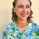 Dangle earrings with emerald green rectangular stud and matching circular gem drop, set in gold for a classic and elegant finish.
