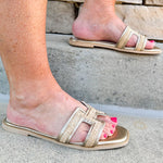 Ena Raffia H-Cutout Slides featuring a breathable raffia strap and modern H-cutout design, styled on a clean surface to showcase their chic, casual summer look and cushioned footbed
