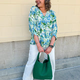 Loose-fit blouse with V-neckline and 3/4 sleeves in a pink, orange, and purple floral tie-dye print, styled for an effortless, vibrant look.