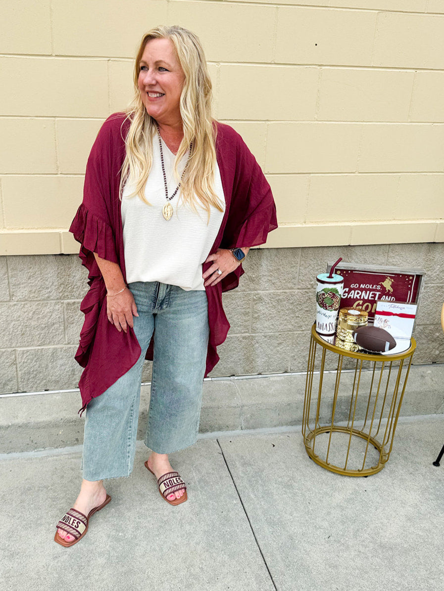 Lightweight oatmeal V-neck top with cap sleeves, styled casually for Gameday. The neutral tone and relaxed fit offer a versatile, polished look.