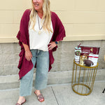 Lightweight oatmeal V-neck top with cap sleeves, styled casually for Gameday. The neutral tone and relaxed fit offer a versatile, polished look.