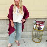 Lightweight oatmeal V-neck top with cap sleeves, styled casually for Gameday. The neutral tone and relaxed fit offer a versatile, polished look.