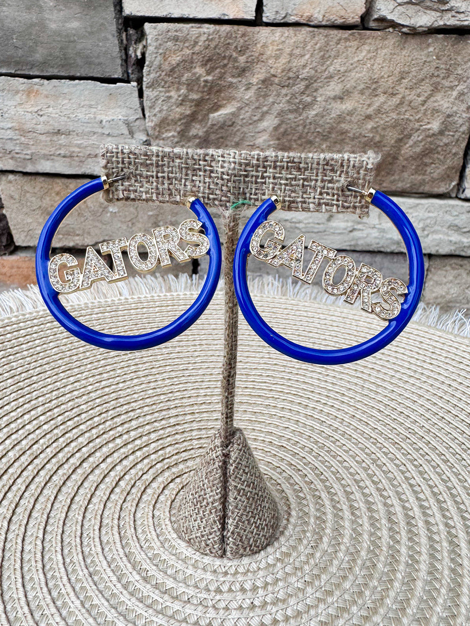 Royal blue hoop earrings featuring crystal "GATORS" lettering with gold-tone hardware.