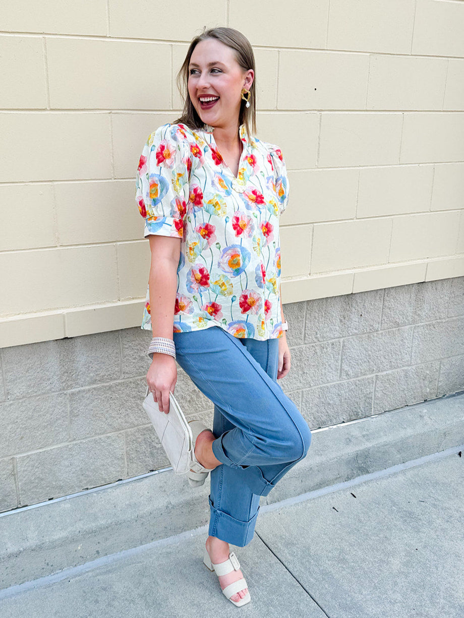 Lightweight floral blouse with puff sleeves and a pleated collar in soft cream with colorful floral print