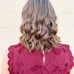 Sleeveless mini dress in rich garnet with 3D floral appliqué, scalloped embroidered hem, and side pockets. Elegant, textured, and perfect for fall or Gameday.