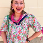 Colorful floral short sleeve blouse with tie sleeves and contrast neckline