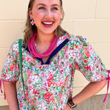 Colorful floral short sleeve blouse with tie sleeves and contrast neckline