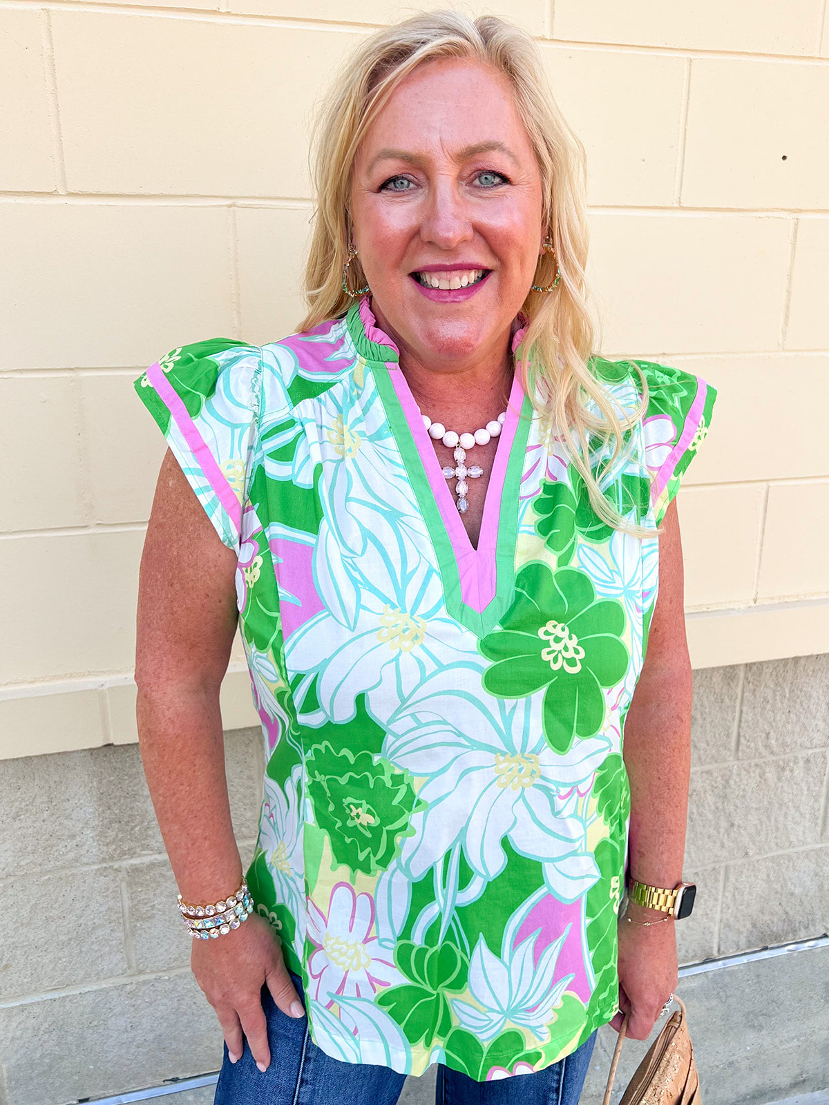 Green floral blouse featuring white, blue, and pink botanical prints with a lightweight, feminine silhouette.