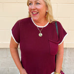 Garnet short sleeve sweater knit top with cream contrast trim, a front chest pocket, and a classic crew neckline.
