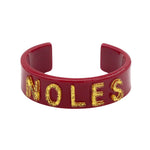 Garnet resin cuff bracelet with gold glitter NOLES lettering.