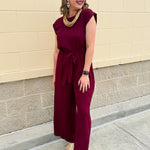 Garnet short-sleeve jumpsuit with elastic waist, front tie, high scoop neckline, and side pockets. Sporty, flattering, and perfect for Gameday style.