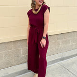 Garnet short-sleeve jumpsuit with elastic waist, front tie, high scoop neckline, and side pockets. Sporty, flattering, and perfect for Gameday style.