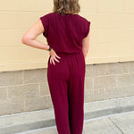Garnet short-sleeve jumpsuit with elastic waist, front tie, high scoop neckline, and side pockets. Sporty, flattering, and perfect for Gameday style.