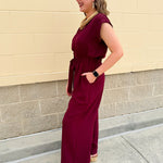 Garnet short-sleeve jumpsuit with elastic waist, front tie, high scoop neckline, and side pockets. Sporty, flattering, and perfect for Gameday style.