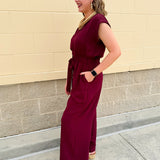 Garnet short-sleeve jumpsuit with elastic waist, front tie, high scoop neckline, and side pockets. Sporty, flattering, and perfect for Gameday style.