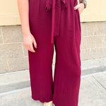 Garnet short-sleeve jumpsuit with elastic waist, front tie, high scoop neckline, and side pockets. Sporty, flattering, and perfect for Gameday style.