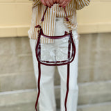 Clear crossbody stadium bag with garnet straps and gold hardware, perfect for stylish game day looks.